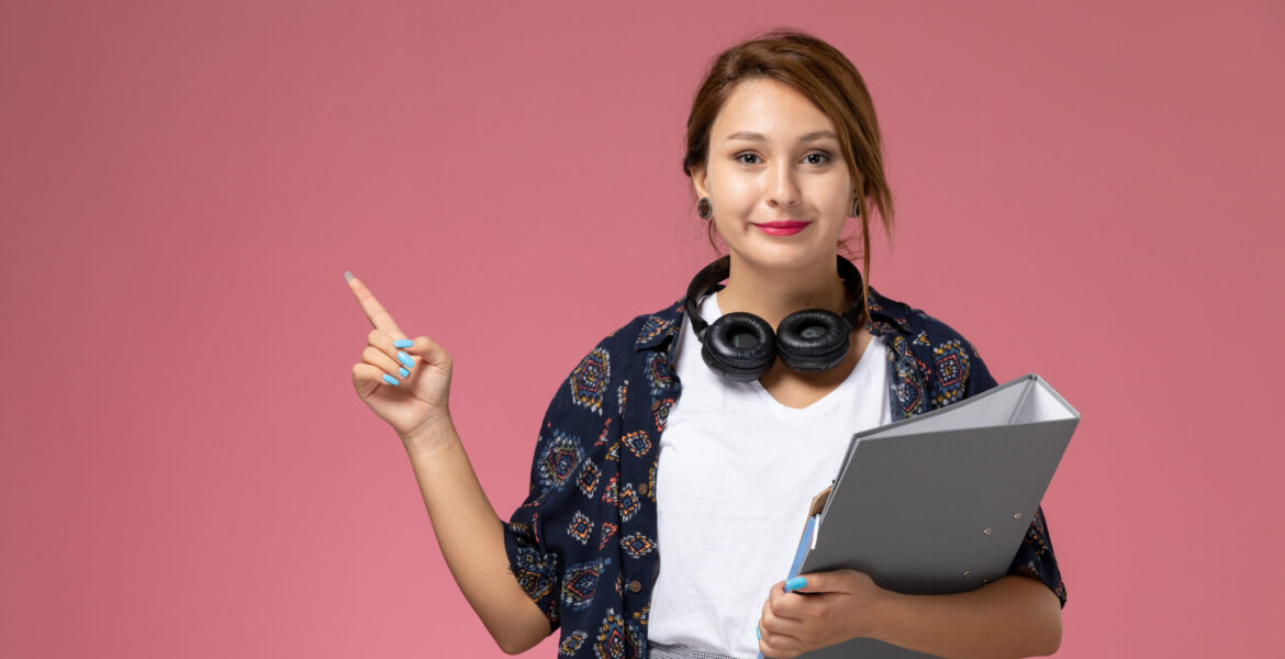 front-view-young-female-student-white-t-shirt-with-grey-file-posing-smiling-pink-background-lesson-university-college-study-book